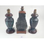 A pair of bronze finish oriental table lamps and a similar one with relief decoration