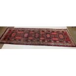 A full pile red ground Iranian runner with crossed door design, 306 x 95 cm