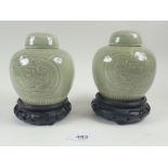 A pair of Chinese Celadon ginger jars with incised decoration, 11cm tall, on stands