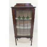 An Edwardian mahogany single door display cabinet with green and clear glass lead glazed door