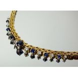 A Gubelin 18 carat gold triple link necklace set central sapphire flanked by eight diamonds and