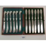 A set of six silver handled tea knives Sheffield 1908 cased and another set of pistol handled ones