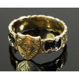 A Georgian mourning ring with shield flanked by floral engraving and black enamel decoration to band