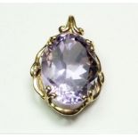 An amethyst oval cut pendant in decorative 9 carat gold mount, 2.7 x 2cm