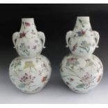 A pair of Chinese famille rose double gourd form vases painted flowers and butterflies, 30cm on
