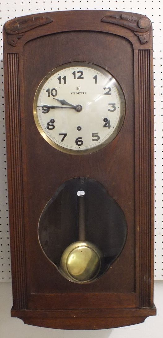 A French 1950's striking oak wall clock with pendulum and key