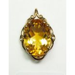 A citrine oval pendant in decorative 9 carat gold mount, 2.7cm x 2cm