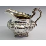 A silver cream jug of compressed form embossed flowers, London 1838, by CF, 228g