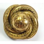 A Victorian 18 ct gold brooch of circular form with applied wire decoration and locket back (vacant)