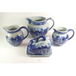 Three large blue and white pottery jugs plus a cheese/butter dish