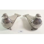A pair of Persian silver plated trinket boxes in the form of exotic birds decorated in a chased form