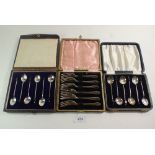 Two sets of silver coffee bean spoons and a set of plated cake forks, all cased