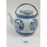 An early Chinese blue and white porcelain teapot decorated circular motifs, with metal handle