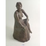 A bronzed sculpture of a seated girl, 36cm tall