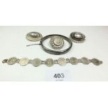 A silver bangle, three Victorian silver brooches and a coin bracelet