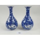 A pair of late 19th century Japanese Arita blue and white bottle vases with flared rims, fielded