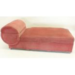 An Art Deco pink upholstered ottoman day bed with circular head rest
