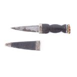 Scottish sgian dubh, 3½ ins blade, carved ebony handle, in covered wooden sheath with silver collar,
