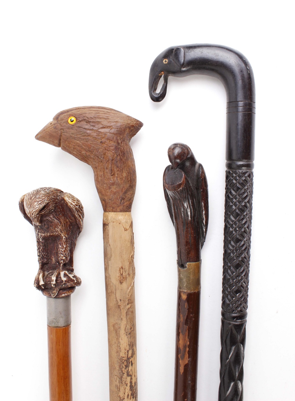 Four wooden walking sticks with decorative animal figured handles