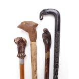 Four wooden walking sticks with decorative animal figured handles