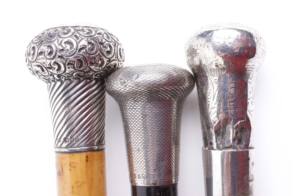 Two tapered walking canes with decorative silver pommels, together with one similar - Image 2 of 4