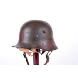 A WWI German M16 helmet, having faded painted camo design, stamped BF62 to inside, remanence of hand