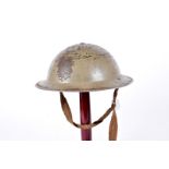 A WWII British Brodie helmet, green painted steel helmet, having 1940 marked liner