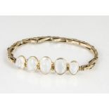A moonstone and yellow metal bracelet, the five cabochon collet set graduated moonstones on an