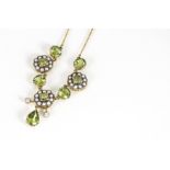 An Edwardian style peridot, seed pearl and diamond fringe necklace, on a fine yellow metal chain