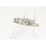 A five stone diamond 18ct gold ring, the brilliant cuts in claw setting on a scroll gallery of