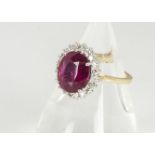 A certified ruby and diamond cluster ring, the oval claw set mixed cut ruby surrounded by a bezel of