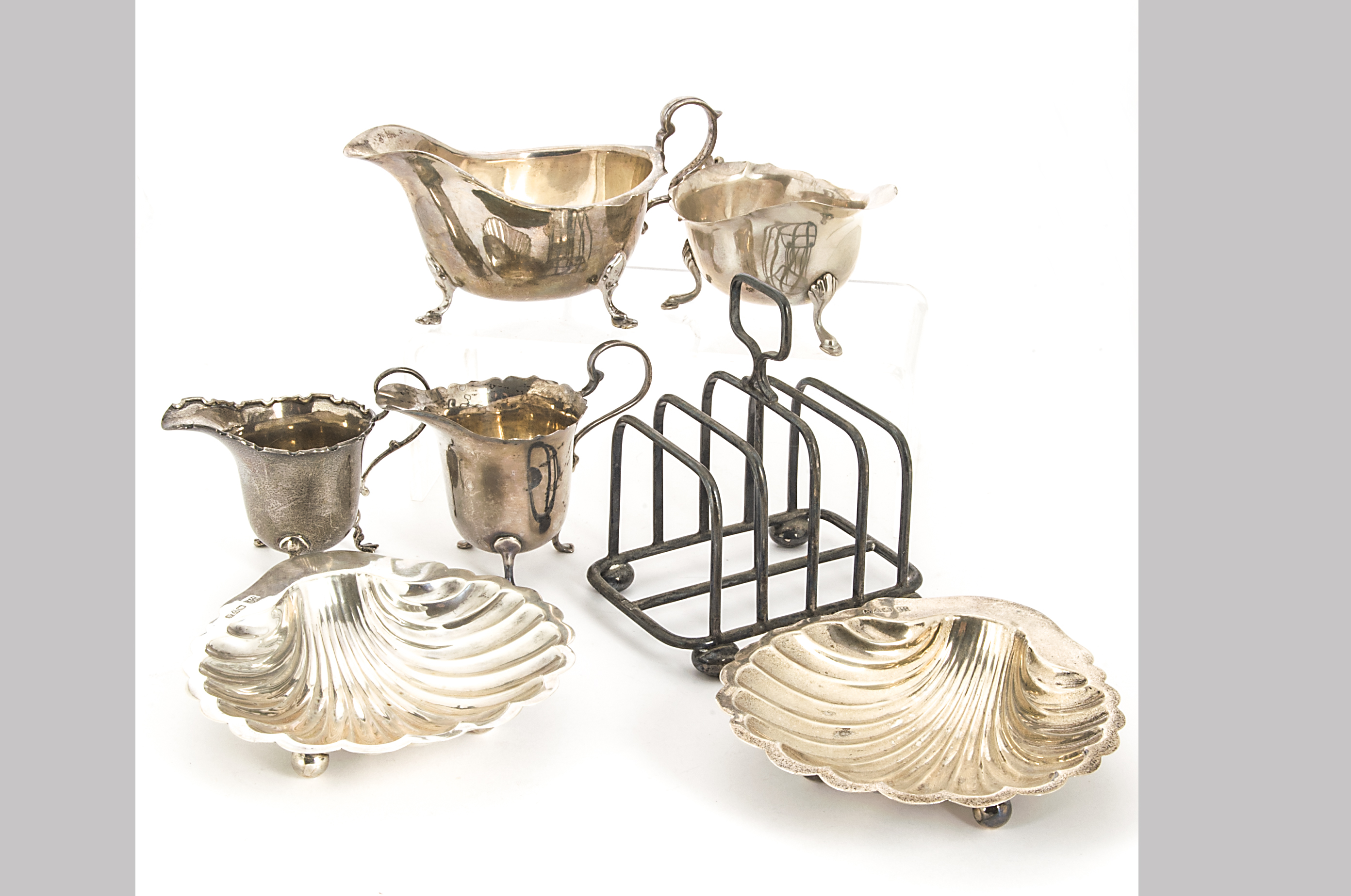 A pair of early George V silver shell shaped butter dishes by HEB & FEB, Chester 1913, together with