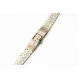 A c1960s Accurist 9ct white gold lady's wristwatch, 11mm on an integrated textured 9ct white gold