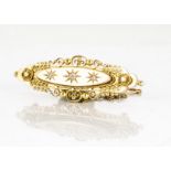 A Victorian 15ct gold diamond set bar brooch, the old cuts in gypsy setting on an oval mount with