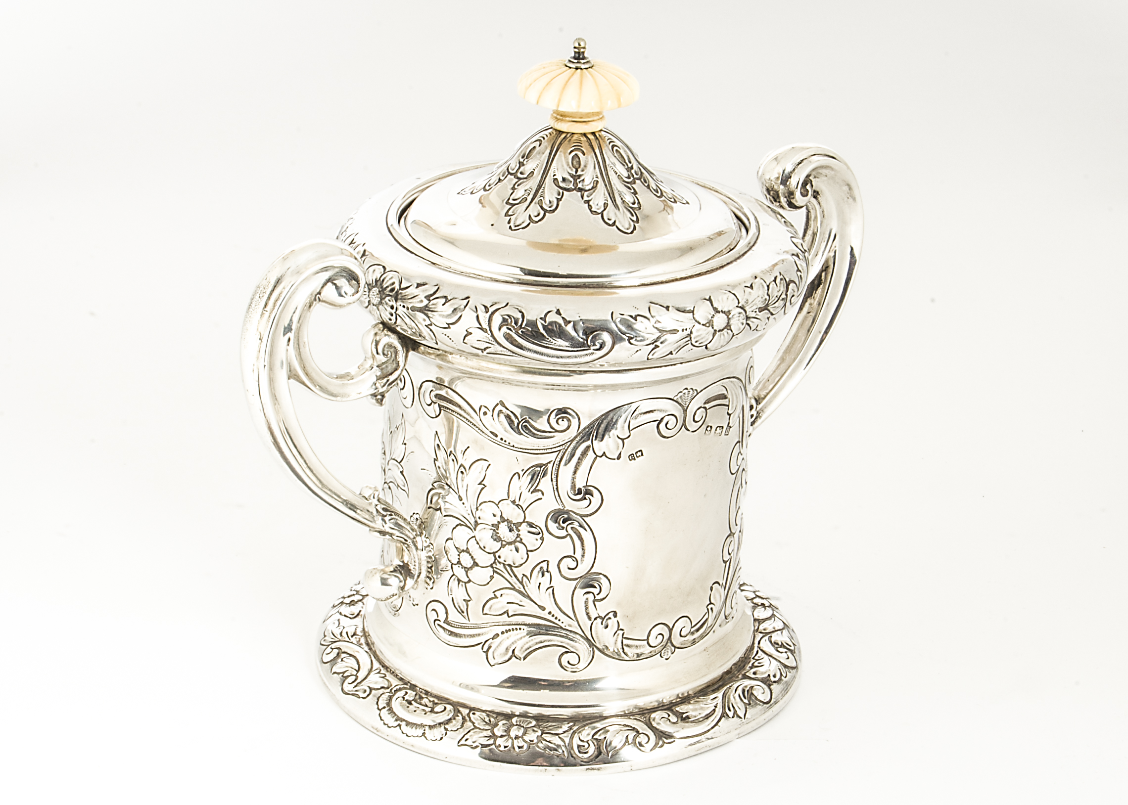 An Edwardian silver biscuit barrel by CW, twin handled with raised floral and rococo motifs,