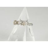 A three stone brilliant cut white gold diamond set dress ring, the claw set stones in plain white