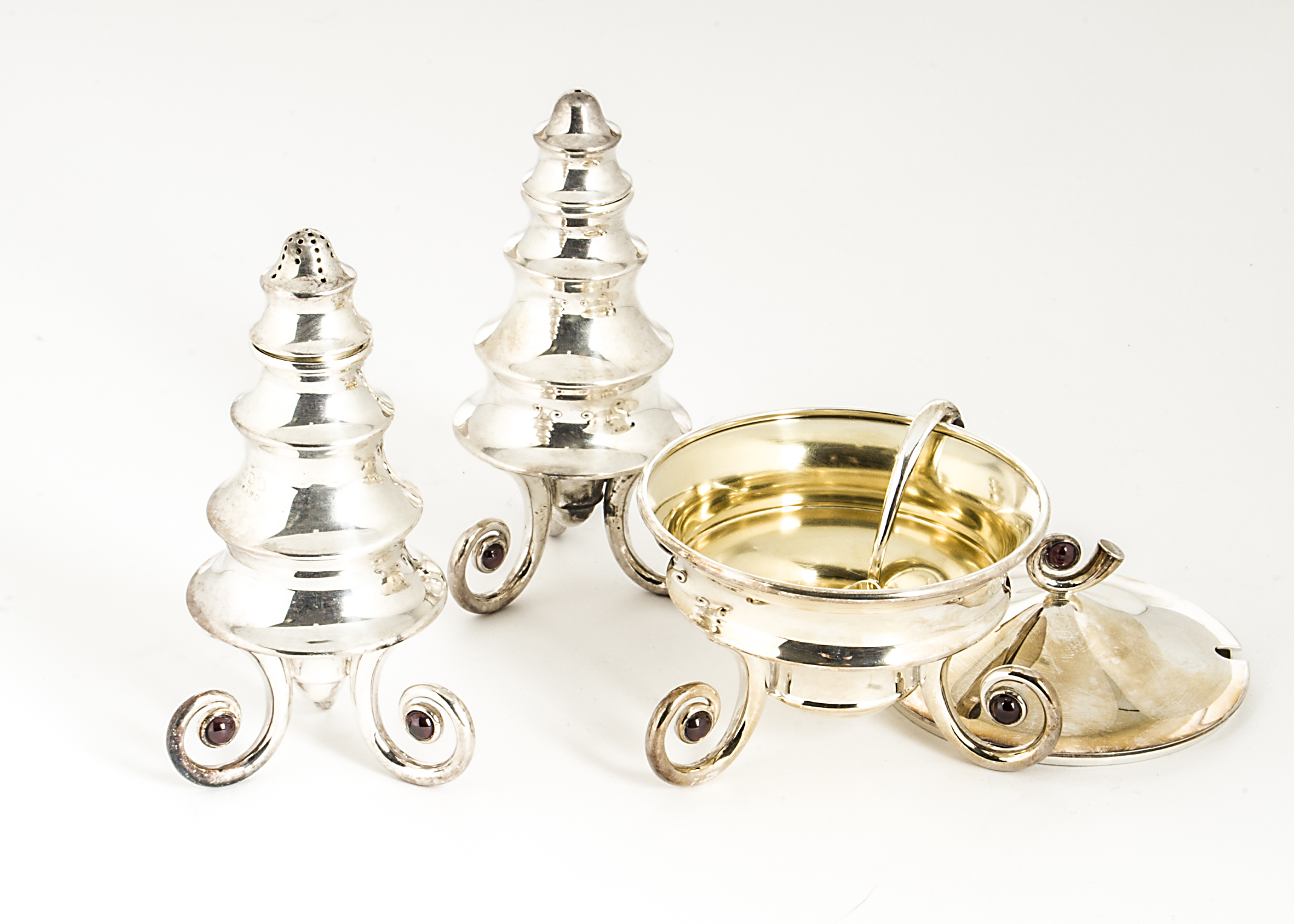 A modern three piece cruet set from Garrard, the abstract conical and waisted salt and pepper on