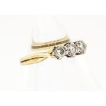 An 18ct gold three stone diamond ring, the three claw set brilliant cuts in white gold claw