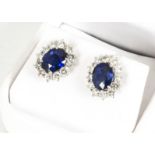 A pair of 18ct white gold sapphire and diamond cluster earrings, the oval mixed cut sapphires