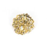 An Indian silver gilt and white sapphire set floral brooch, the closed back settings with engraved