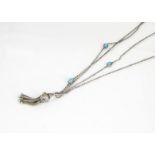 A white metal and simulated turquoise muff chain, with tassel drop, doubled up, together 42cm