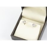 A pair of brilliant cut white gold mounted diamond ear studs, the claw sets with post settings,