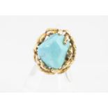 A continental yellow metal and turquoise dress ring, the boulder stone in a textured organic style