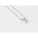 An 18ct white gold diamond pendant and chain, the brilliant cut in tension setting on a square