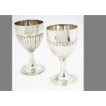 Two Victorian silver trophy goblets, one marked London 1875, with half fluted bowls on socle