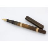 An Edwardian Watermans Ideal fountain pen, light brown barrel with two 9ct gold mounts, with brown