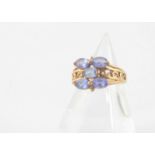 A 9ct gold tanzanite and diamond dress ring, the oval mixed cut tanzanite with diamond set edge on a