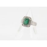 An emerald and diamond dress ring, in the Art Deco style, the emerald cut in four claw setting