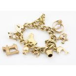 A 9ct gold curb link bracelet, with multiple charms and a padlock clasp including an elephant, gem