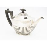 A George V silver teapot from Mappin & Webb, Sheffield 1926, with fluted lower and applied black